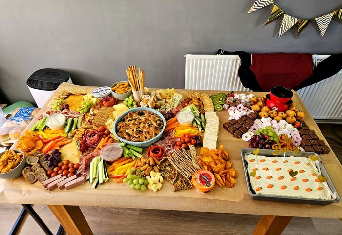 Large grazing table with cheese, cured meats, focaccia and a celebration cake
